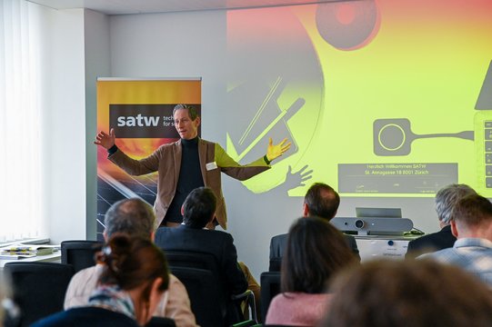 Lecturer presents in front of an audience in a conference room